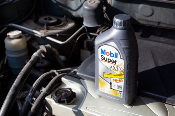 Sostituzione dell’olio nel motore dell’auto, primo piano. Olio sintetico Mobil Super per motori.